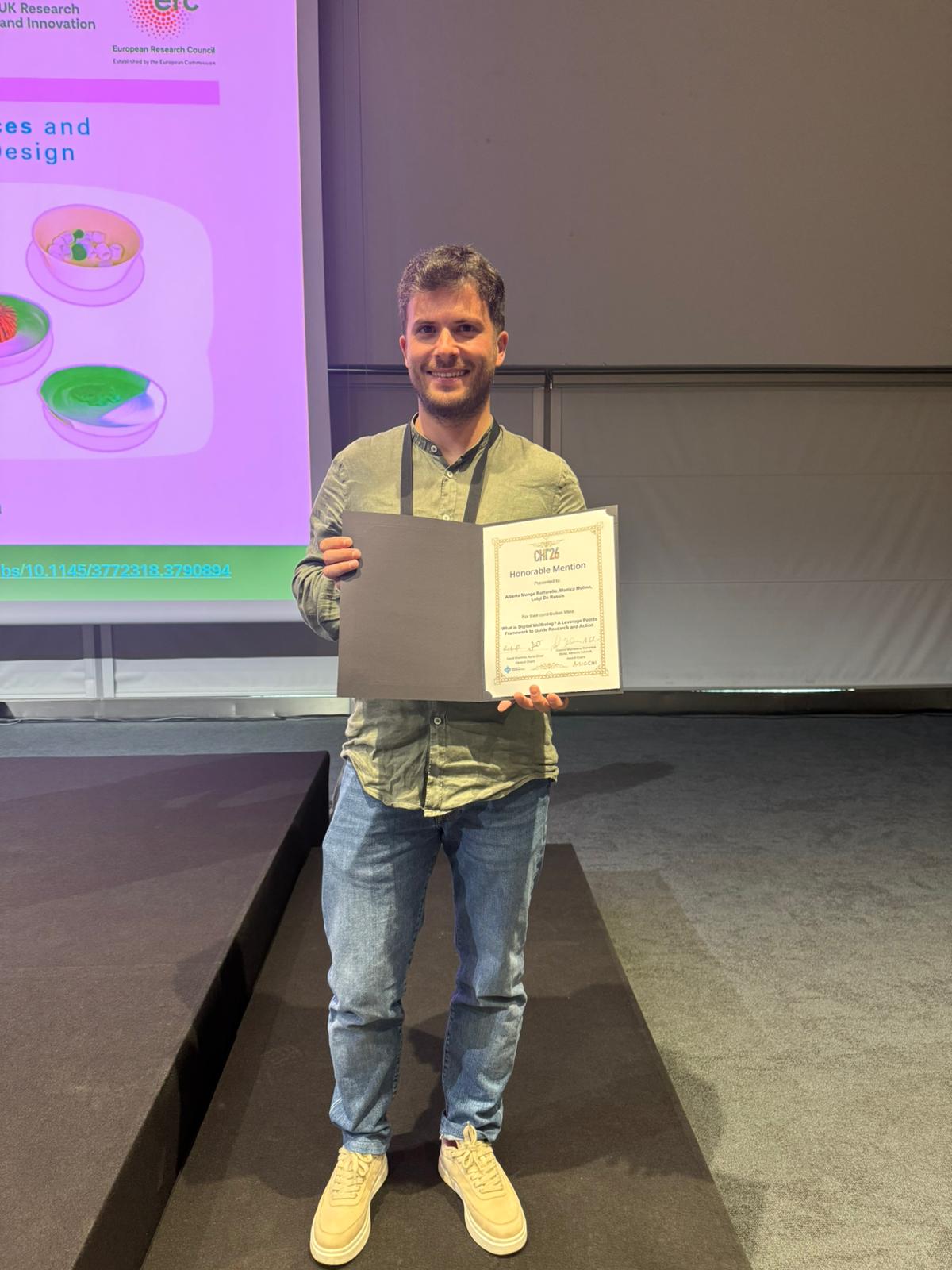 Alberto Monge Roffarello holding the Honorable Mention certificate at CHI 2026